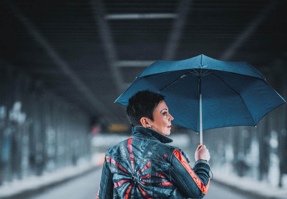 Foto von Heidi vom Lande, mit Regenschirm auf einer Brücke
